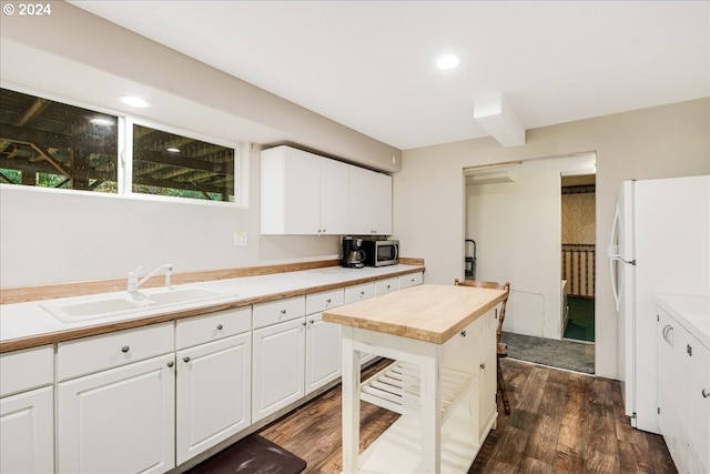 kitchen with white cabinets, white refrigerator, sink, and dark hardwood / wood-style flooring