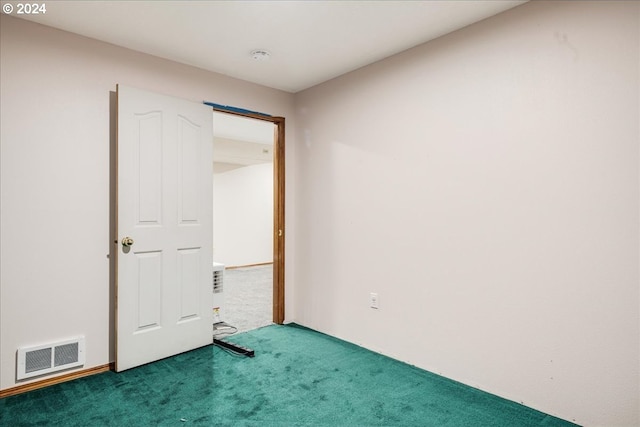 unfurnished room featuring dark carpet