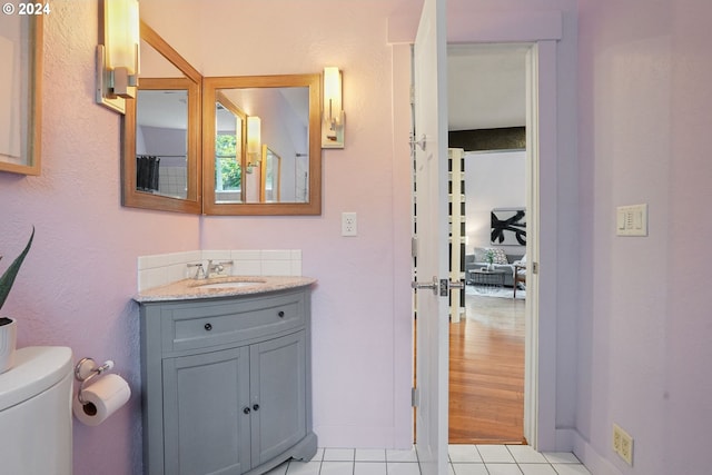 bathroom with tile patterned flooring, vanity, and toilet