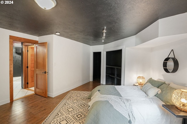 bedroom with a textured ceiling and light wood-type flooring