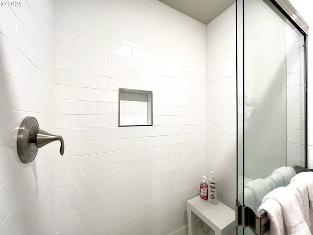 bathroom featuring a shower with shower door