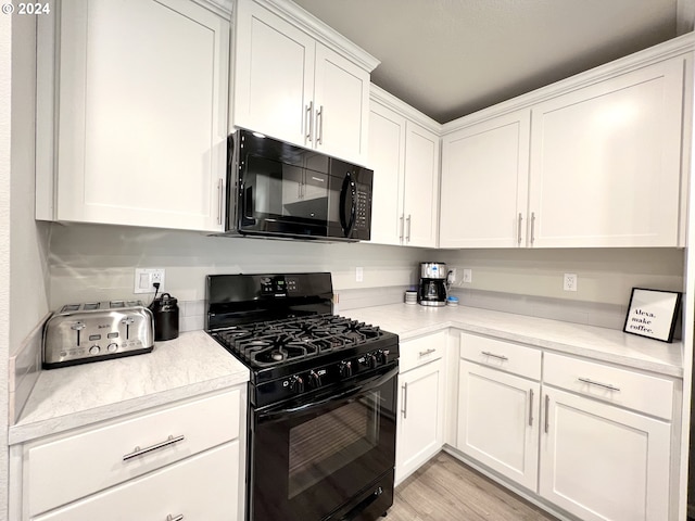 kitchen featuring black appliances, white cabinets, and light wood-type flooring