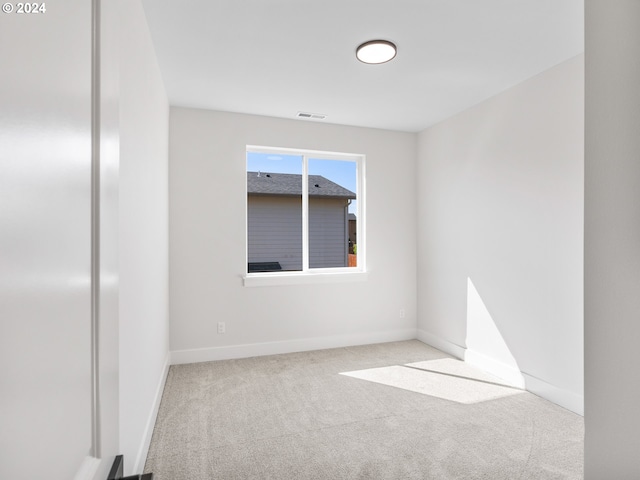 carpeted spare room with baseboards and visible vents