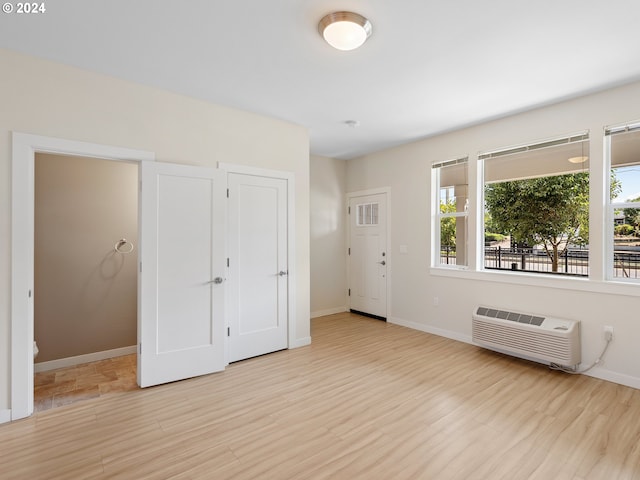 interior space featuring a wall unit AC and light hardwood / wood-style floors