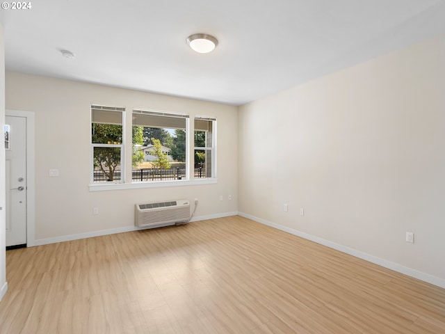 spare room featuring light hardwood / wood-style floors and a wall mounted air conditioner