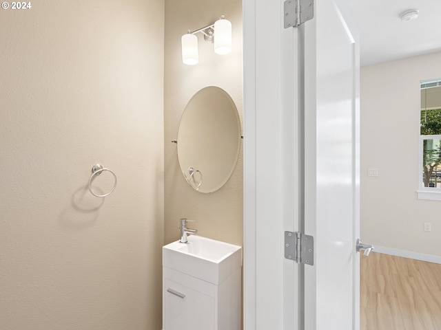 bathroom with a wealth of natural light, vanity, and wood-type flooring