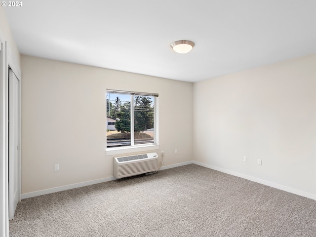 spare room with carpet floors and a wall unit AC