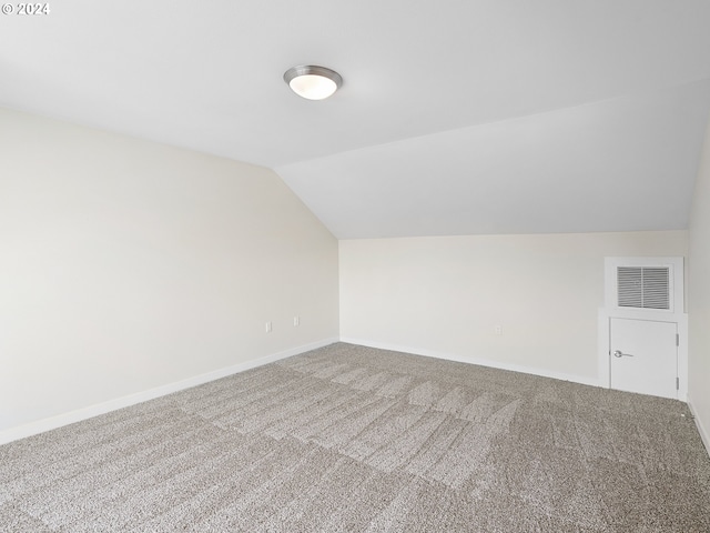 additional living space with carpet and vaulted ceiling