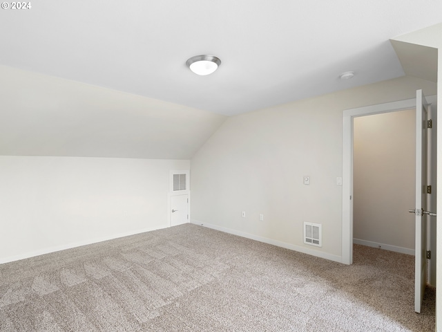 additional living space featuring carpet and lofted ceiling