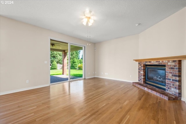 unfurnished living room featuring a textured ceiling, a fireplace, light hardwood / wood-style flooring, and sink