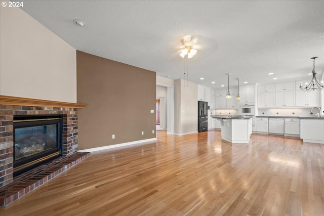 kitchen with oven, an inviting chandelier, high quality fridge, white cabinetry, and a breakfast bar area