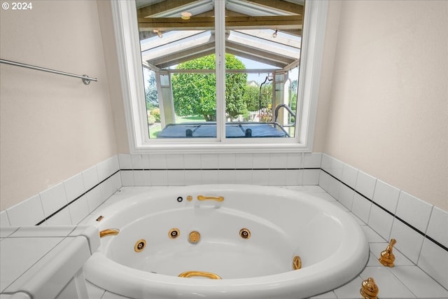 bathroom featuring a relaxing tiled tub and vaulted ceiling