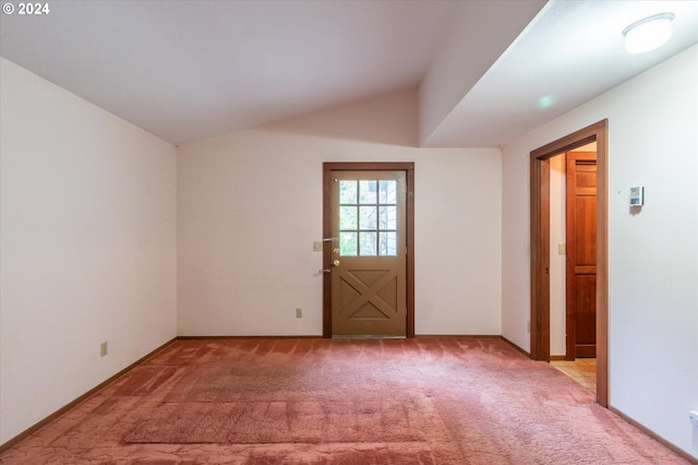 spare room featuring light colored carpet and lofted ceiling