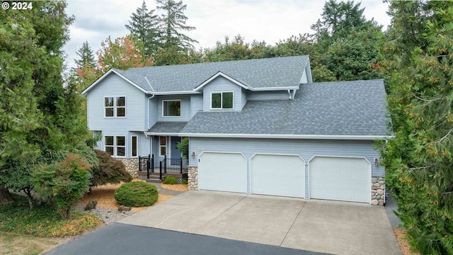 view of front of property with a garage, stone siding, roof with shingles, and driveway