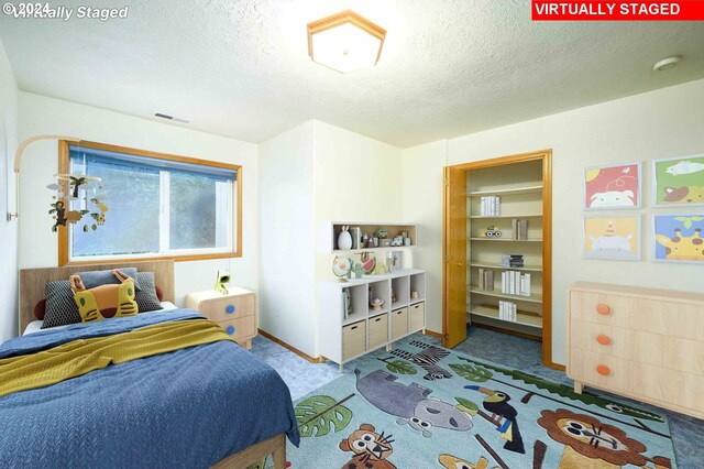 carpeted bedroom featuring a textured ceiling