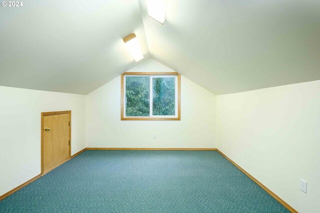 additional living space with vaulted ceiling and carpet