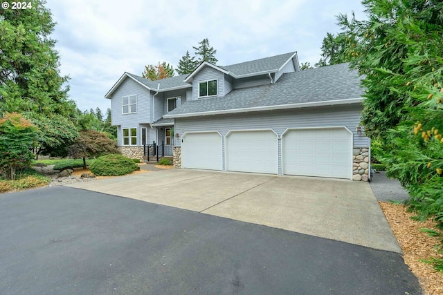 view of front of house featuring a garage, stone siding, driveway, and a shingled roof