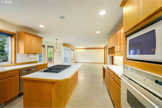 kitchen featuring recessed lighting, light countertops, appliances with stainless steel finishes, hanging light fixtures, and a center island