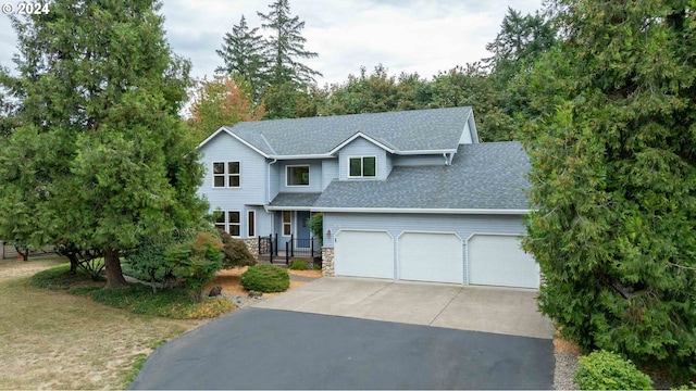 traditional-style house with an attached garage, stone siding, a shingled roof, and concrete driveway