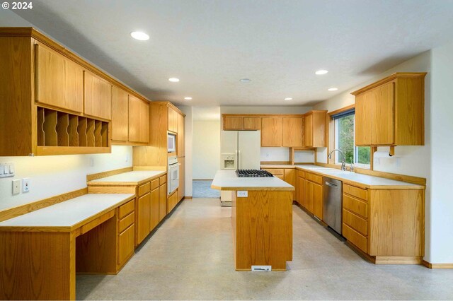 kitchen with appliances with stainless steel finishes, a kitchen island, and sink