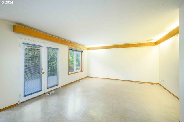 spare room with finished concrete floors, french doors, visible vents, and baseboards