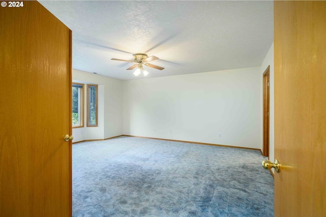 unfurnished room featuring ceiling fan, a textured ceiling, baseboards, and carpet flooring