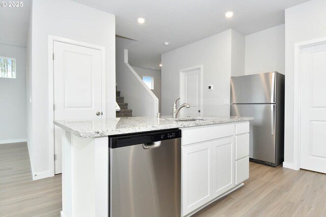 964 NE 14th St, Battle Ground, WA 98604 - kitchen featuring stainless steel appliances, light wood-type flooring, white cabinets, a kitchen island with sink, and a sink