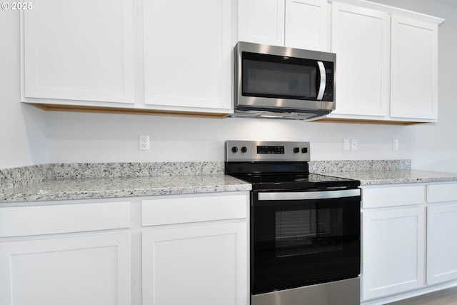 964 NE 14th St, Battle Ground, WA 98604 - kitchen with stainless steel appliances, white cabinetry, and light stone countertops