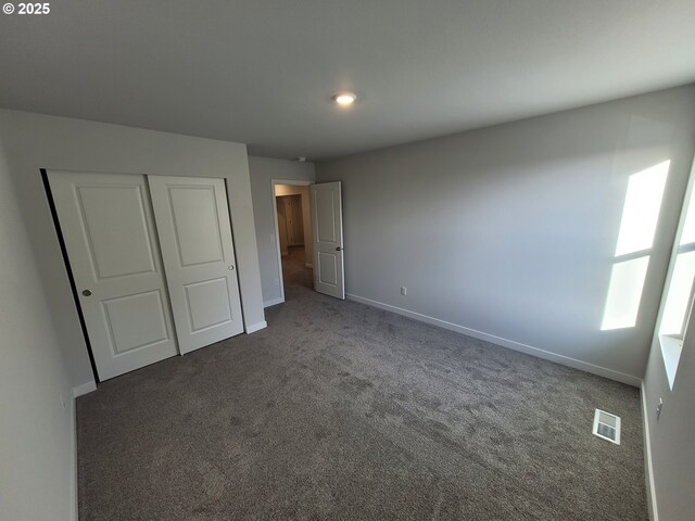 unfurnished bedroom featuring a closet, baseboards, visible vents, and carpet flooring