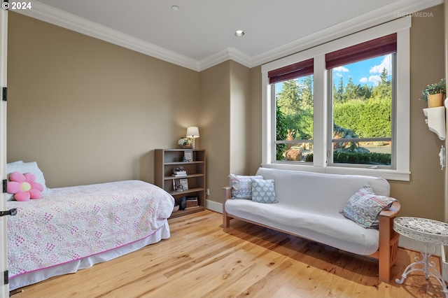 bedroom with ornamental molding and light hardwood / wood-style floors