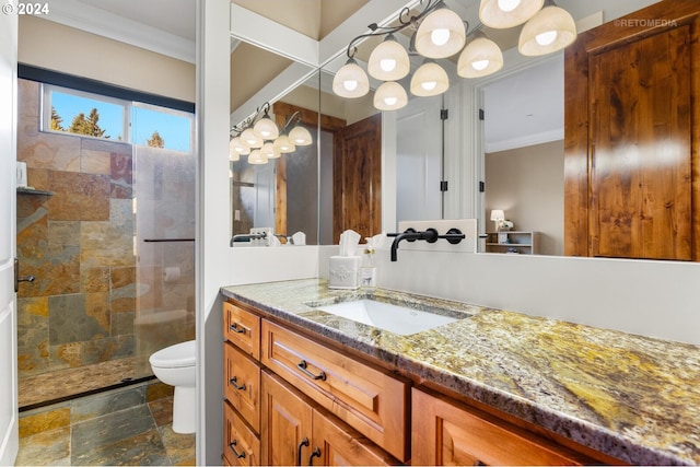 bathroom with vanity, toilet, tiled shower, and ornamental molding