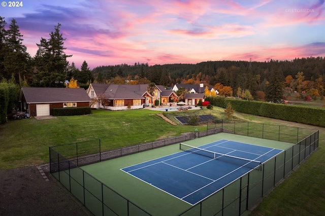 view of tennis court with a yard