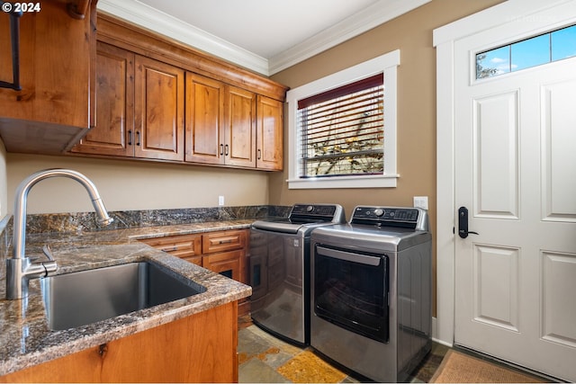 laundry area featuring cabinets, ornamental molding, sink, and washer and dryer