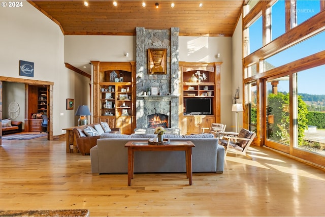 living room with a fireplace, light hardwood / wood-style floors, wood ceiling, and high vaulted ceiling