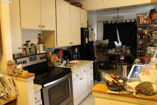 kitchen featuring a chandelier, light countertops, stainless steel electric range oven, and white cabinetry