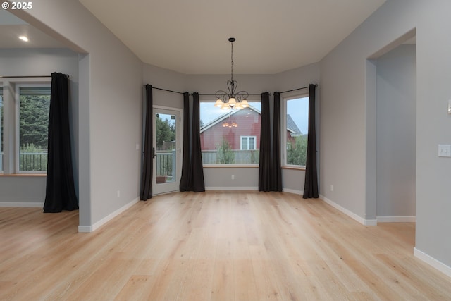 unfurnished dining area featuring plenty of natural light, wood finished floors, and baseboards