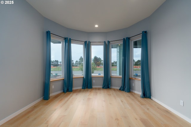 spare room with recessed lighting, baseboards, and wood finished floors