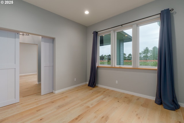 spare room featuring baseboards, wood finished floors, and recessed lighting