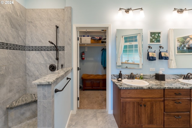 bathroom with tiled shower and vanity