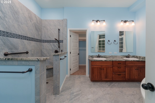 full bath featuring a walk in closet, double vanity, a sink, and walk in shower