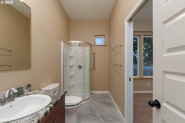 bathroom with toilet, a shower stall, baseboards, and vanity