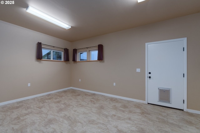 spare room with baseboards