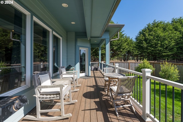 wooden deck featuring a lawn