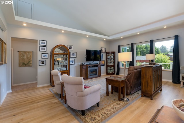 living room with light hardwood / wood-style flooring and a high ceiling