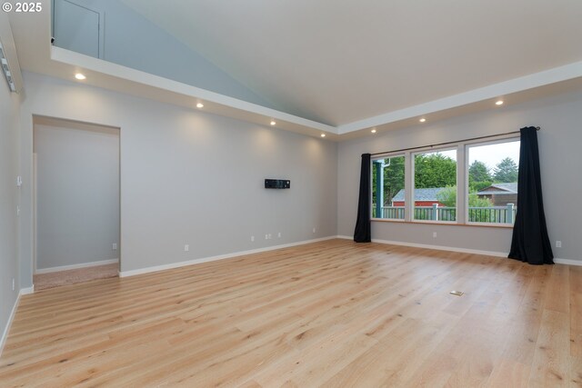 living room with an inviting chandelier, a raised ceiling, light hardwood / wood-style floors, and a healthy amount of sunlight