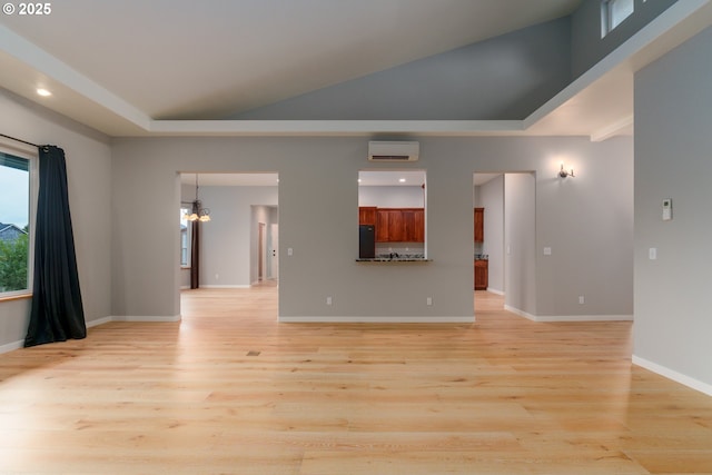 unfurnished living room featuring light wood-style floors, a chandelier, vaulted ceiling, and baseboards