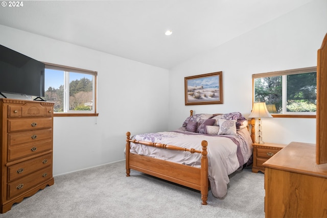 carpeted bedroom featuring lofted ceiling and multiple windows