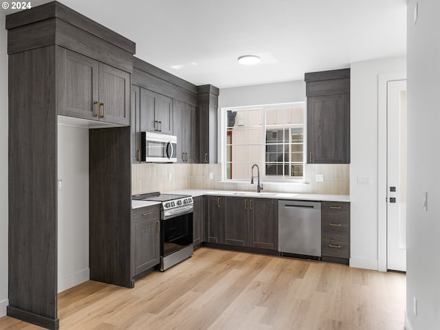 kitchen with sink, decorative backsplash, light hardwood / wood-style floors, stainless steel appliances, and dark brown cabinets