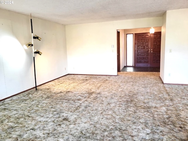 unfurnished room featuring a textured ceiling and carpet flooring