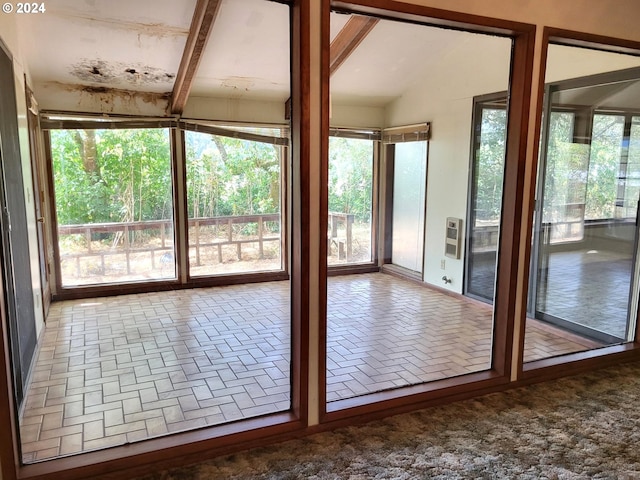 doorway to outside featuring heating unit and lofted ceiling